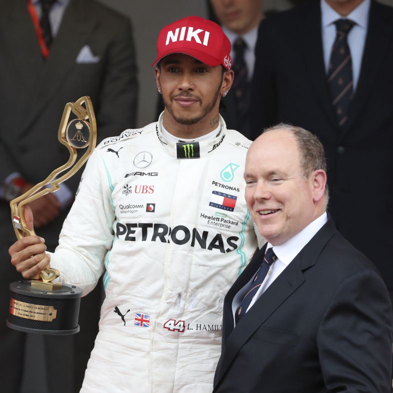 Race winner Lewis Hamilton of Great Britain and Mercedes GP celebrates with Prince Albert of Monaco on the podium after the F1 Grand Prix of Monaco