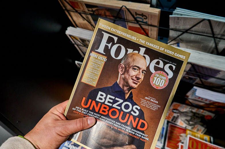 AMSTERDAM, NETHERLANDS - OCTOBER 08, 2018: Forbes magazine with Jeff Bezos on the cover in a hand. Jeff Bezos is president of Amazon. Forbes is an American family-controlled business magazine - Photo 136337850 © Dennizn | Dreamstime.com