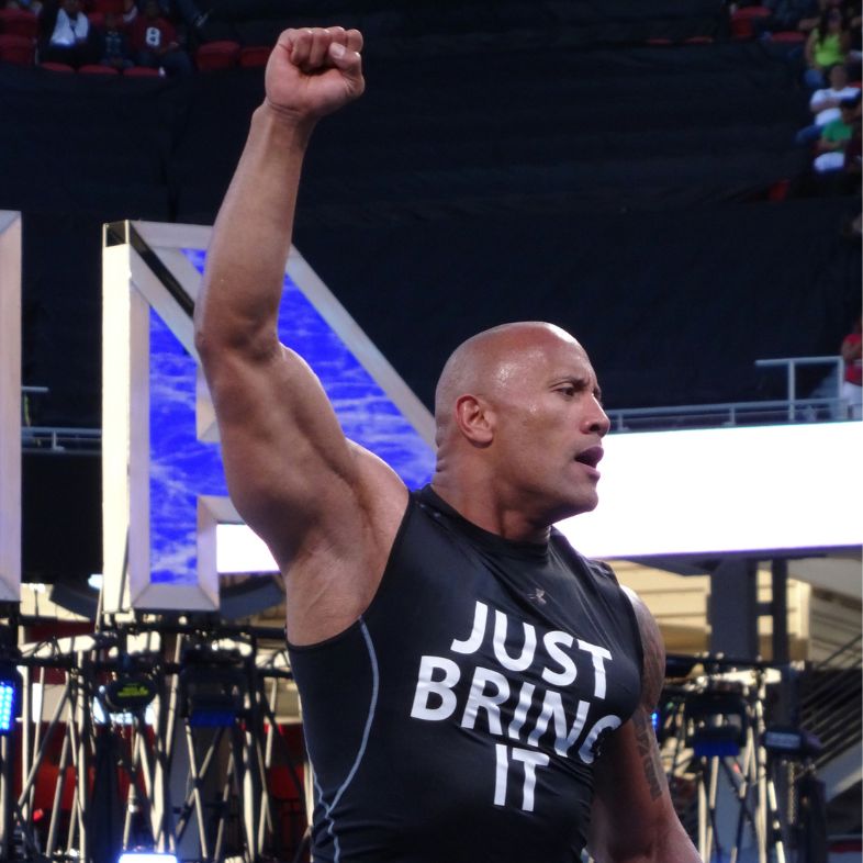 SANTA CLARA - MARCH 29: International superstar the Rock, Dwayne Johnson, wearing a just bring it shirt holds arm in the air as he makes a surprise entrance in the ring Wrestlemania 31 at the Levi s Stadium in Santa Clara, California on March 29, 2015